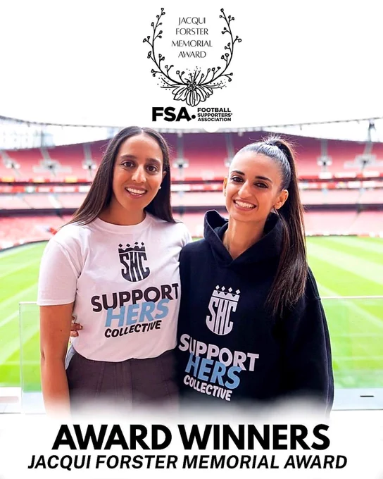 Co-Founders Hina Shafi and Kiki Christofi standing smiling with their arm around each other at Arsenal football stadium with the grass pitch & stands in the background, wearing “SupportHERS Collective” tops with logos on the front. Hina Shafi on left in white T-Shirt & Kiki Christofi on the right in black hoodie. Above is text reading “Jacqui Forster Memorial Award” with the Football Supporters’ Association logo. At the bottom, bold text reads “Award Winners – Jacqui Forster Memorial Award.”
