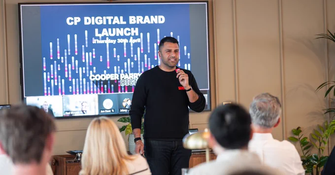 Presenter speaking at the CP Digital Brand Launch with event slide behind.