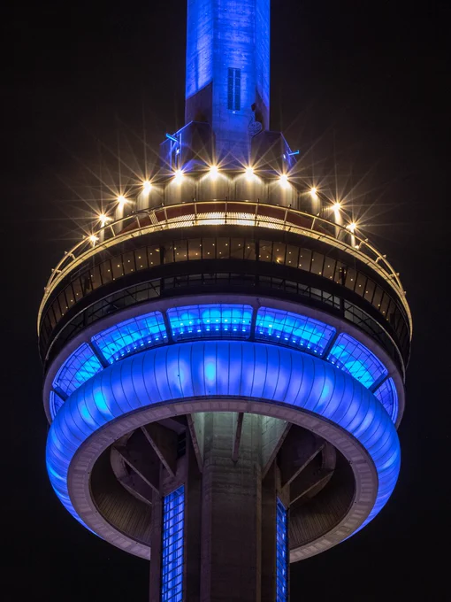 Closeup of the CN Tower at night lit blue/ Gros plan de la Tour CN illuminée en bleu la nuit 