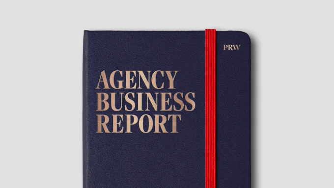 A blue leatherbound book with an embossed gold title reading "Agency Business Report"