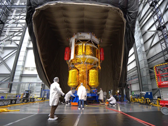 Blue Moon MK1 Endurance, covered in gold, is under a black tent ahead of RF compatibility testing. People in white protective suites are working around it.
