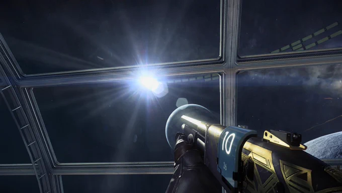 A screenshot from Prey. The player is holding a shotgun with the black and gold Margrave skin and looking out through the wide glass windows of the Talos 1 Arboretum. Outside is the faraway shape of Earth, mostly in shadow, with the sharp bright light of the sun behind it. One of Talos 1’s solar panel rings can be seen encircling the station through the window. The white sunlight reflects hardly off the metal of the shotgun.