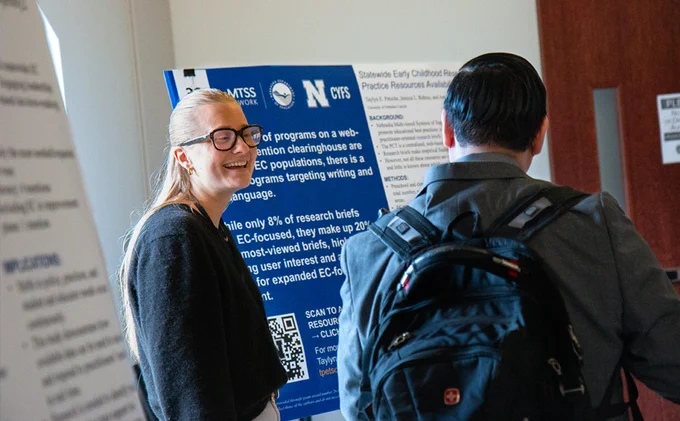 Taylyn Petsche, research assistant with Nebraska MTSS, discusses her poster with an audience member at the CYFS Early Childhood Research Summit.