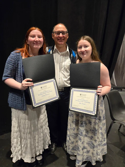 Allison, Emily, and Dr. Purdy are standing and smiling. Allison and Emily are holding their award certificates.