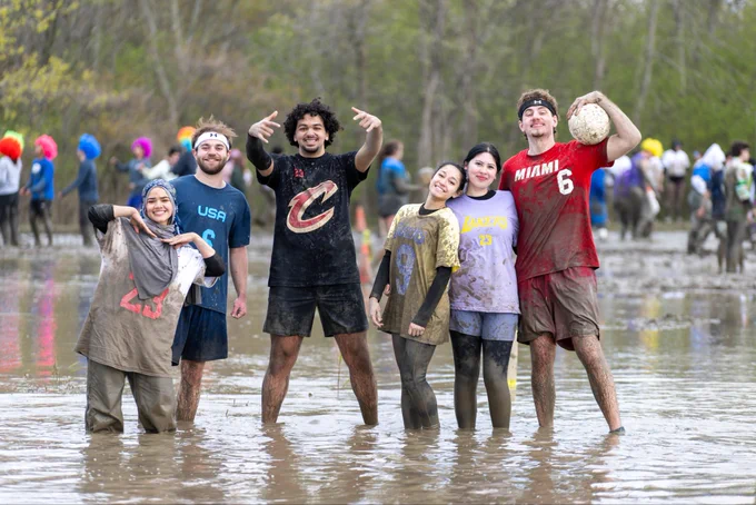 An Oozefest team poses for a photo while standing in the mud.