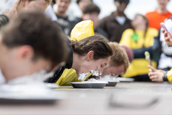 A student devours a pie during a pie eating contest.