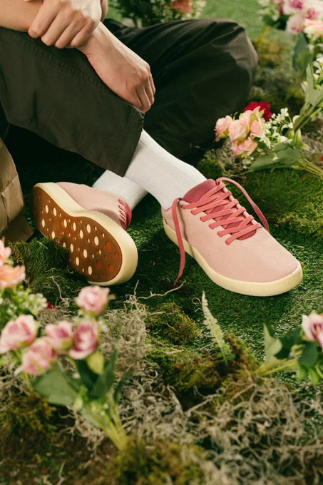 Atoms Sakura Bloom sneakers in soft pink, styled in a spring lifestyle setting with neutral tones and everyday casual clothing.