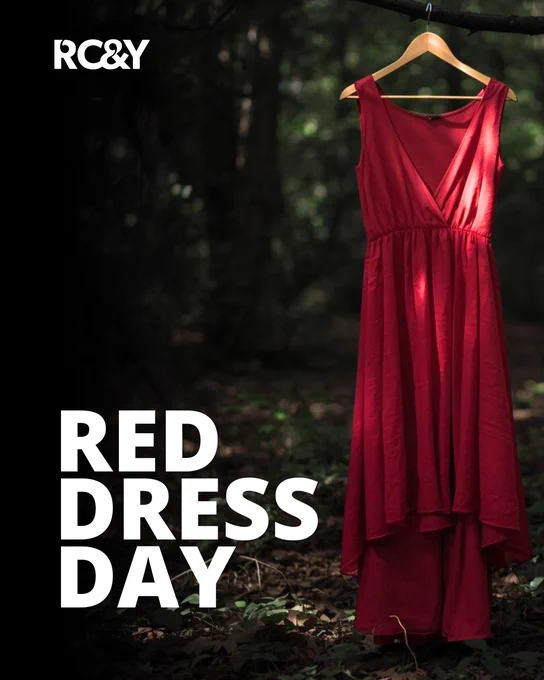 Red dress hanging from a wooden hanger on a tree branch in a forest, lit by soft natural light. Large text reads “Red Dress Day” with the RCY logo in the top left.
