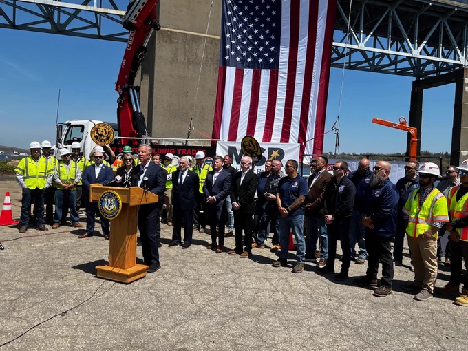 Governor Ned Lamont speaks on the current work being conducted at the Gold Star Memorial Bridge surrounded by federal, state, and local officials and members of the building trades. 
