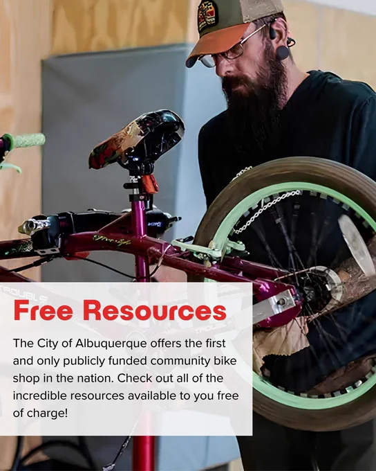 Mechanic repairing a purple BMX bike with green tires at a community bike shop in Albuquerque.
