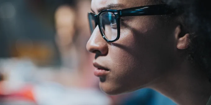 Pictorial representation of CVE-2026-31431. Close-up of a woman wearing glasses and focusing intently on a computer screen.