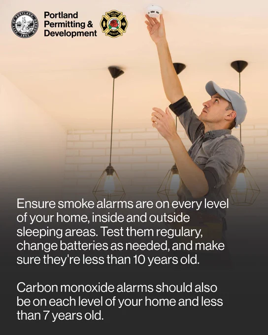 A young, white man stands on a ladder and tests his smoke detector. The text reads, "Ensure smoke alarms are on every level of your home, inside and outside sleeping areas. Test them regularly, change batteries as needed, and make sure they're less than 10 years old. Carbon monoxide alarms should also be on each level of your home and less than 7 years old." 