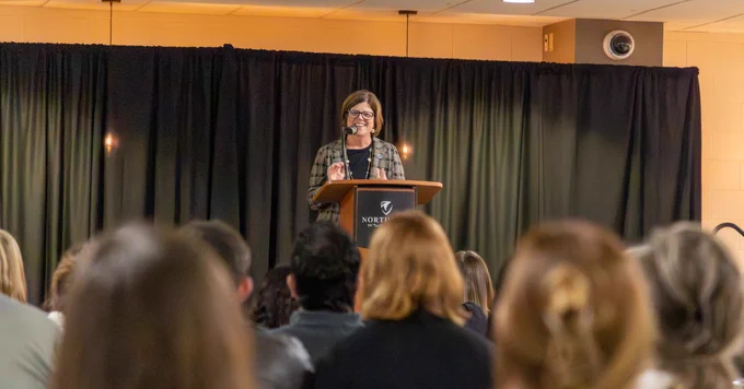A speaker stands at a podium.