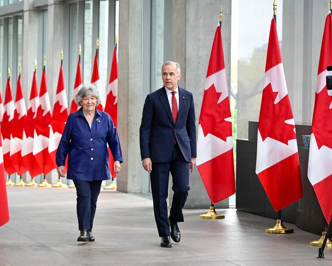 Photo of the Prime Minister of Canada Mark Carney and the Honourable Lise Arbour.

Seen in the background are multiple Canadian flags.
