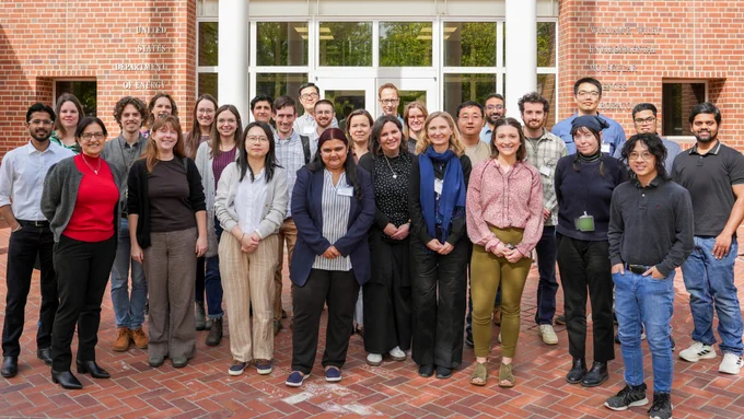 Group photo of event attendees and researchers standing in front of the EMSL entrance.