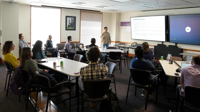 Photo of room filled with event attendees watching a presentation.