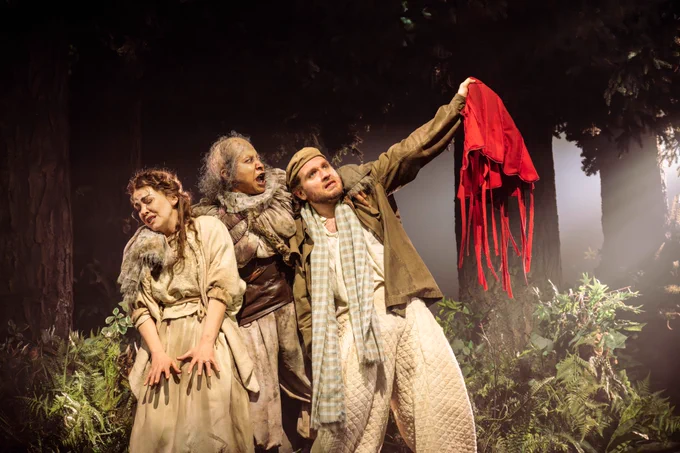 A photo showing three figures in vvintage rustic attire on a beautiful wooden set 