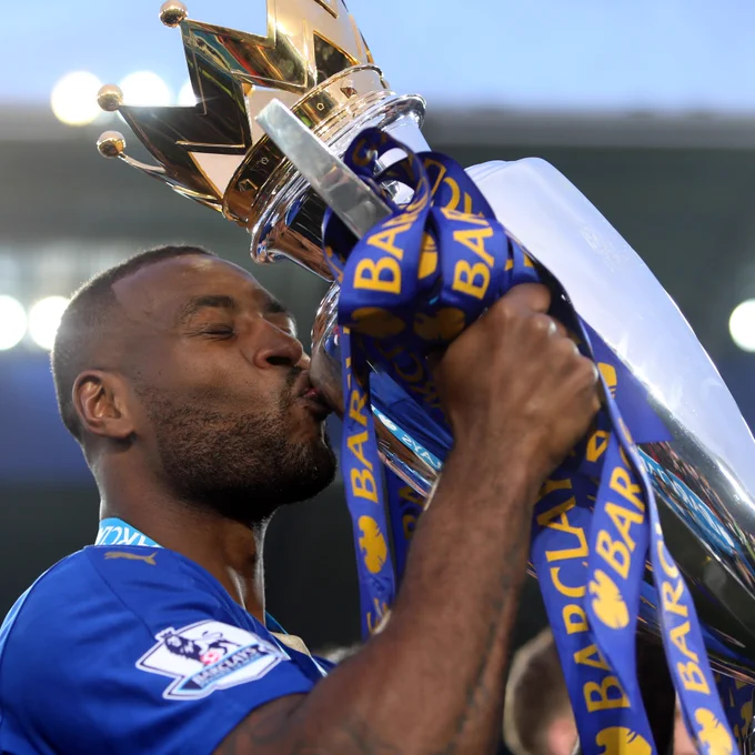 Wes Morgan kisses the Premier League trophy.