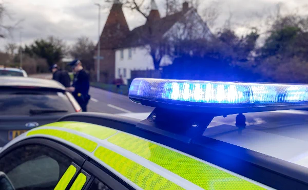 Photo of flashing blue lights on top of a police car.