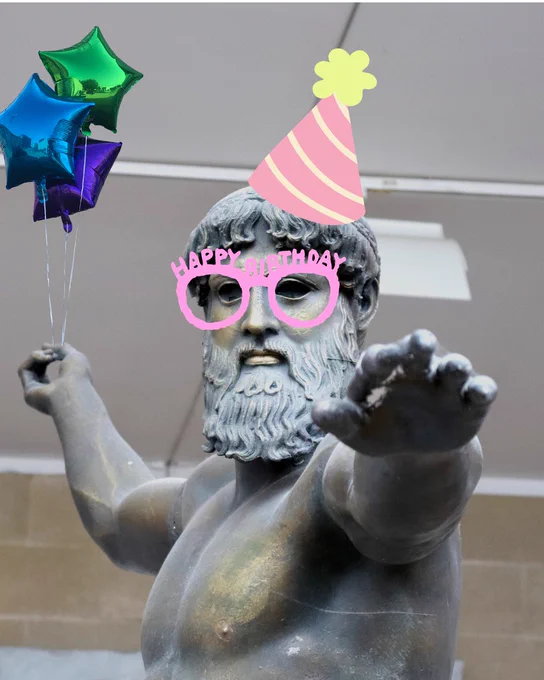 The Artemision bronze, holding some balloons and wearing a party hat and novelty glasses.