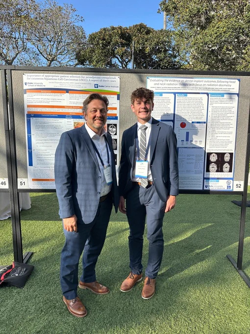 Dr. Jared Robbins and Camden Robbins in front of their scientific poster
