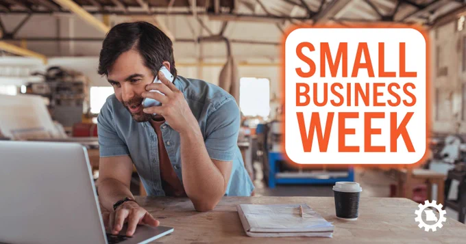 Entrepreneur working on laptop and talking on phone in workshop during Small Business Week.