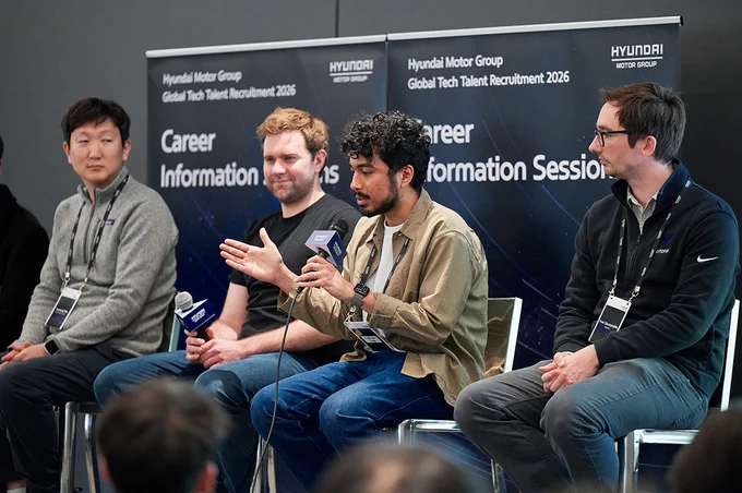 Four individuals are seated on a panel in front of a backdrop displaying "Hyundai Motor Group Global Tech Talent Recruitment 2026" and "Career Information Session." Each person holds a microphone, engaged in discussion. The setting appears professional, suggesting a technology or business-related event.
