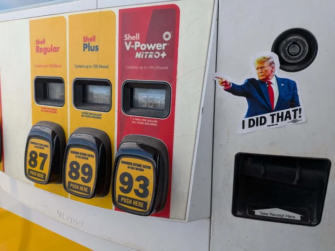 A Shell gas pump with three fuel options: Regular, Plus, and V-Power Nitro . Each display shows a price per gallon, with Plus at $5.09 and V-Power Nitro  at $5.69. A sticker of Donald Trump pointing at the high prices with the text "I DID THAT!" is placed beside the pump panel.