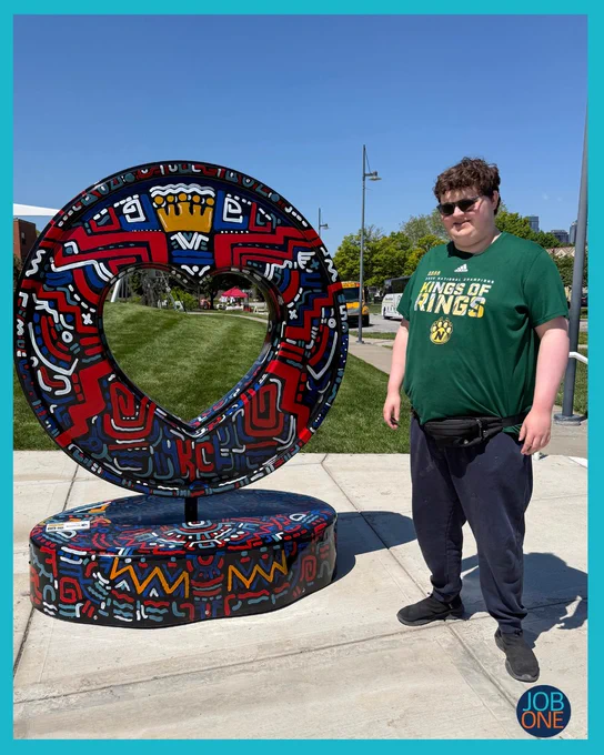 Gage is posing next to a KC Heart statue at the NLBM