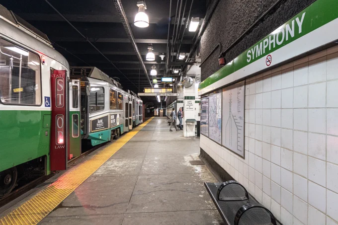 A Green Line train stopped along the platform at Symphony station on the Green Line E Branch.
