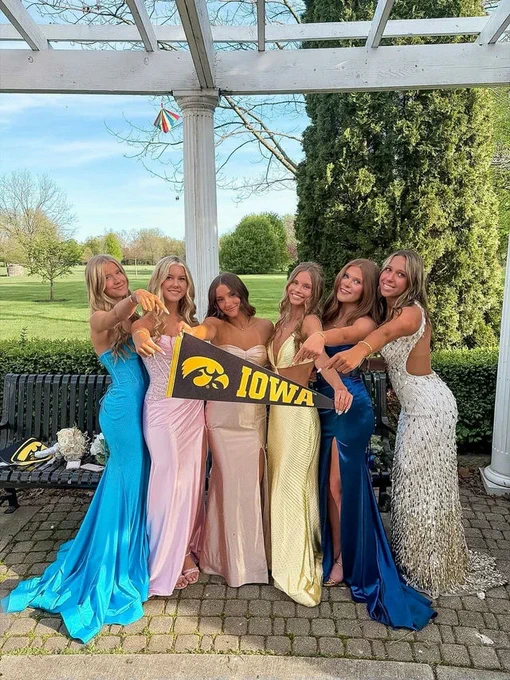 Students dressed up holding an Iowa pennant.
