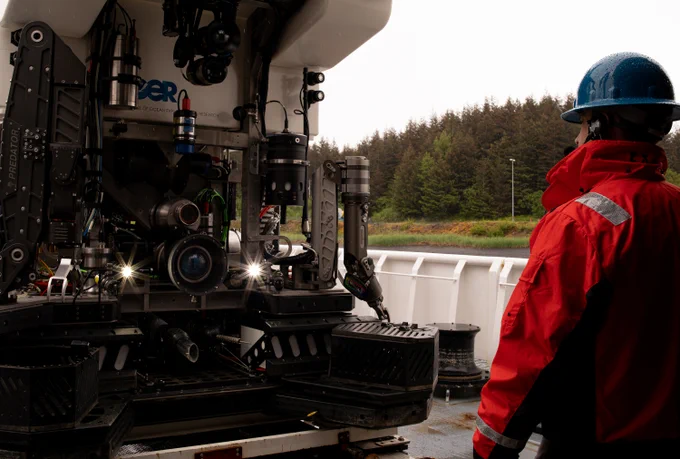 Remotely operated vehicle Deep Discoverer. Image courtesy of Olivia Andrus, Global Foundation for Ocean Exploration, Seascape Alaska

Person wearing a jacket and a helmet while viewing a large robotic device on a ship deck.
