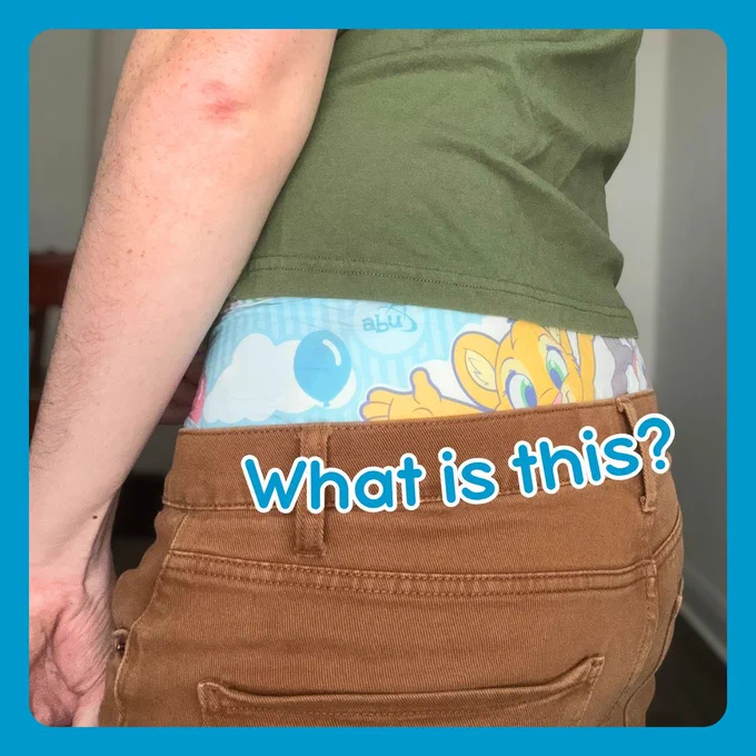 A image of the person in jeans and t-shirt with a colorful undergarment (adult diaper) peeking over the jeans and under the seam of the t-shirt. A text overlayed on the waist of the jeans reads "What is this?".