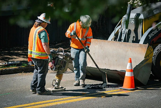 Crews lay asphalt to complete a repair of underground cable in Olympia