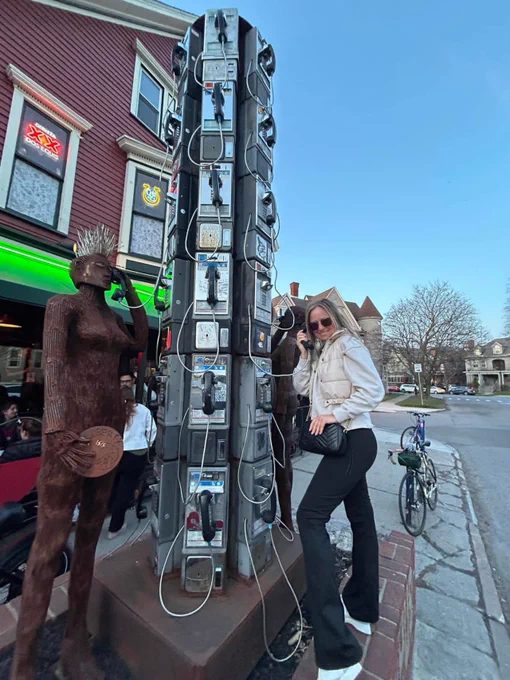 Tara poses for a photo with a tower of payphones