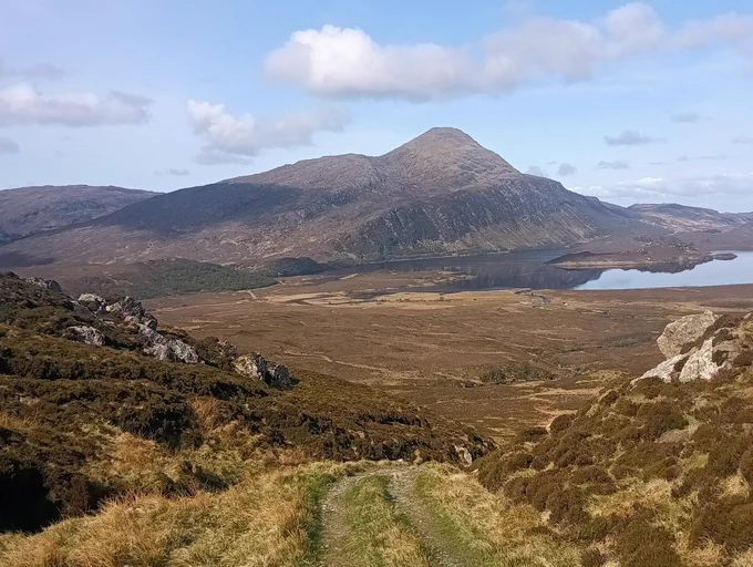 Descending track, wide glen, distant hill