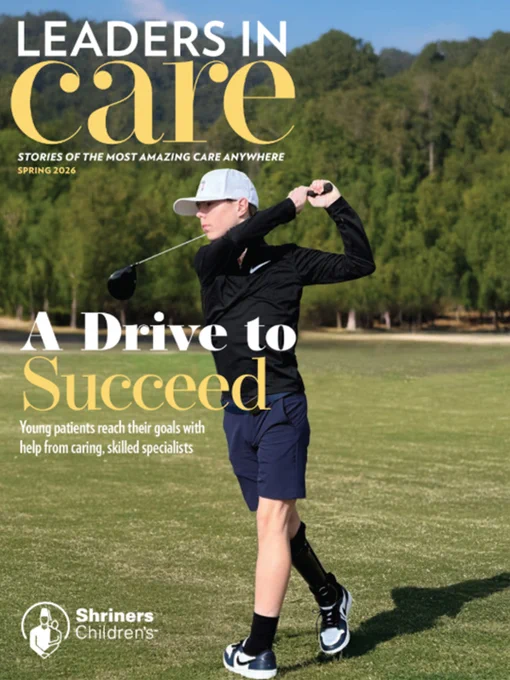 Young golfer with a prosthetic leg swings a club on a sunny course for the cover of Leaders in Care magazine. 