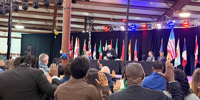 New citizens recite the Oath of Allegiance during a special naturalization ceremony at a cultural festival in Xenia, Ohio.