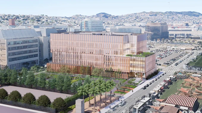A modern multi-story office building with glass facades surrounded by trees and palm-lined streets in an urban area.