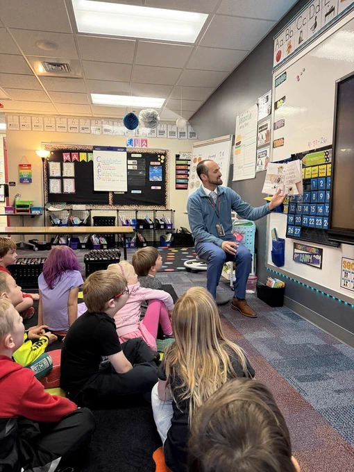 Superintendent Aulie reading in front of Ms. Esse's class