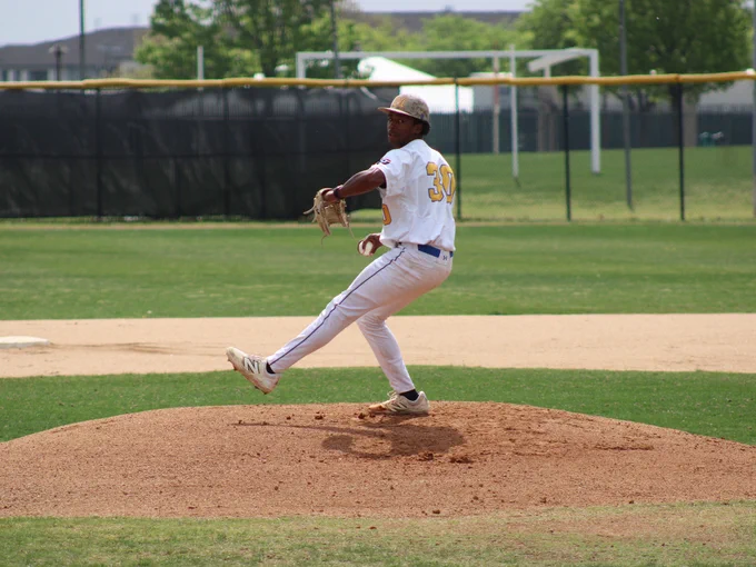 Dallas College Mountain View pitcher Matthew Reynozo reaches back, gripping the ball as he leg-kicks forward with his front foot on a delivery to the plate.