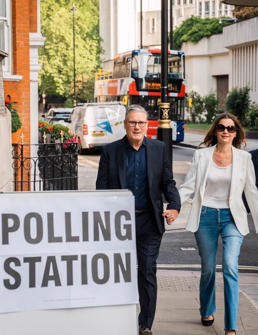 Keir Starmer and Victoria Starmer walking to a polling station to vote