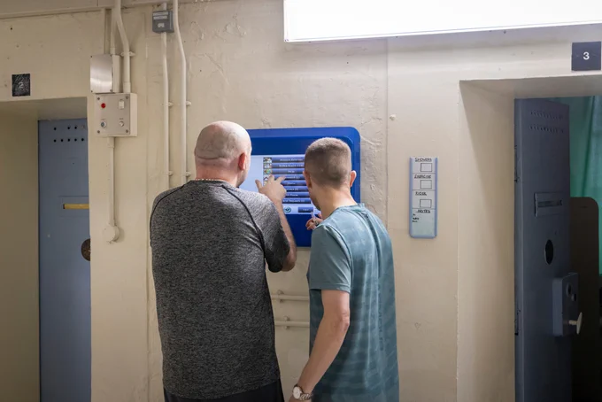 Two prisoners using the Unilink self service kiosk on K-wing inside HMP Liverpool, a category B mens local prison operated by HMPPS, in Walton, Liverpool, United Kingdom. (Photo by Andy Aitchison)