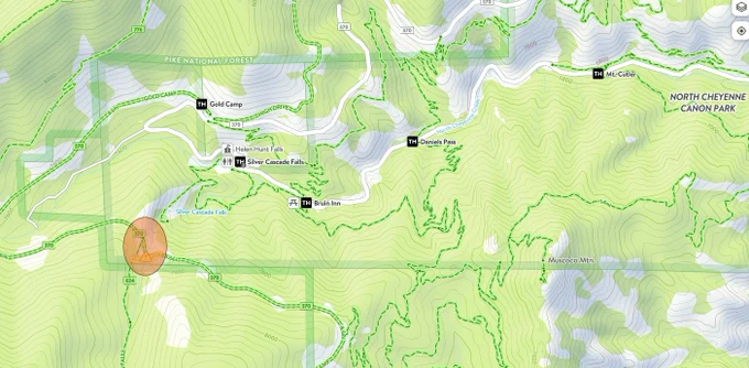 A detailed topographic map displays trails and landmarks within Pike National Forest and North Cheyenne Canon Park. Notable spots include Gold Camp, Silver Cascade Falls, Helen Hunt Falls, and Mount Cutler. The map uses contour lines to indicate elevation and shows roads and paths cutting through the green, hilly terrain.