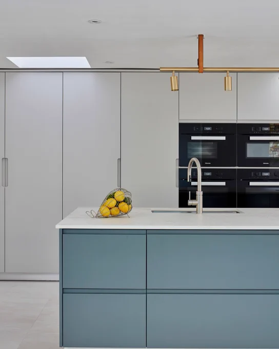handleless kitchen with blue island and floor-to-ceiling cabinets 
