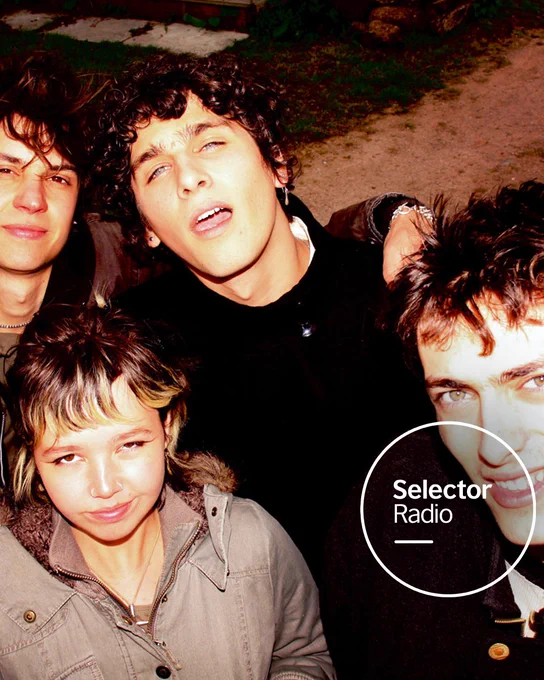 A group of young casually dressed musicians, MORN, crowd together outdoors in a flash-lit portrait with Selector Radio logo in the bottom right of the image.