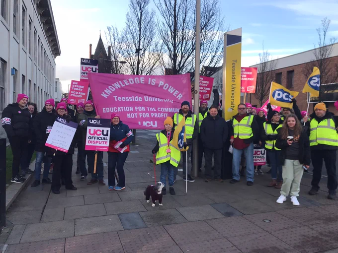 Image shows Teesside University UCU (University and College Union) members with their union banner which says: "Knowledge is Power - Teesside University - Education for the Community, NOT for profit - UCU". PCS trade union flags also present.
