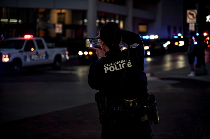 columbus police officer taking a photo of police cruisers