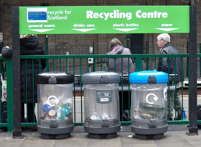 Confusing signage suggesting 4 recycling options when only 3 bins are available.