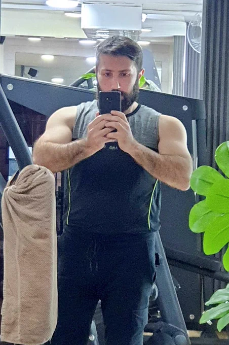 A guy taking a selfie in front of the mirror in the gym during bulk season 